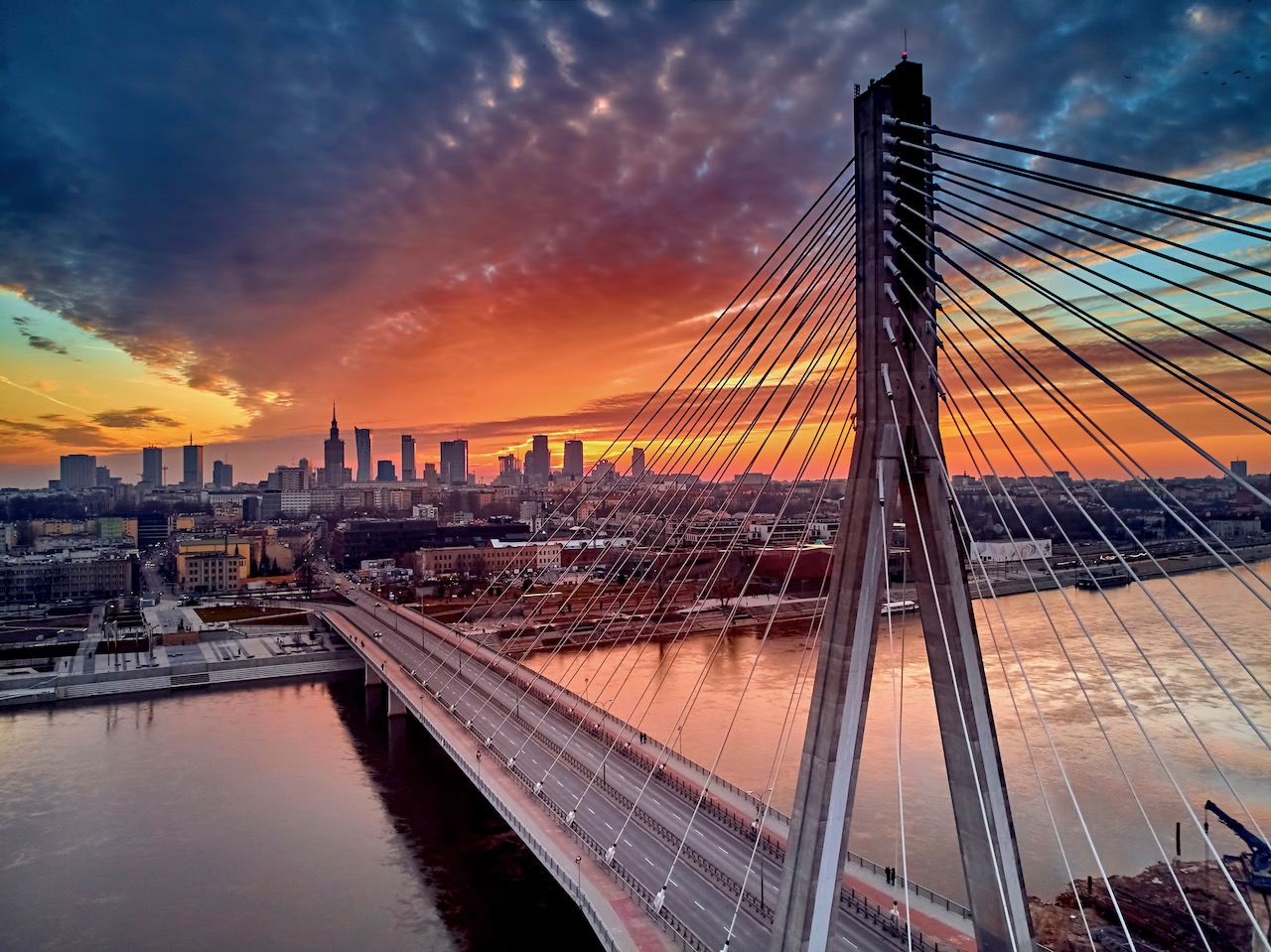 beautiful-panoramic-aerial-drone-sunset-view-to-warsaw-city-center-with-skyscrapers-and-swietokrzyski-bridge--en--holy-cross-bridge----is-a-cable-stayed-bridge-over-the-vistula-river-in-warsaw--poland
